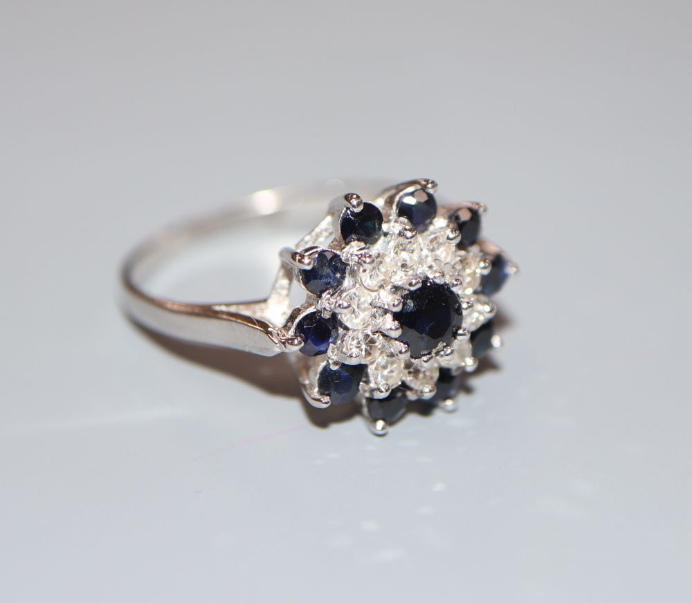 A modern 18ct white gold, sapphire and diamond cluster ring, size S, gross 4.7 grams.